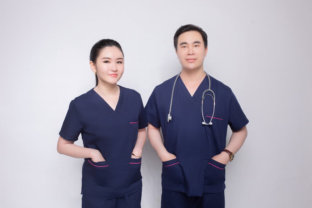 Portrait of a confident male and female medical practitioners in uniform with stethoscope.